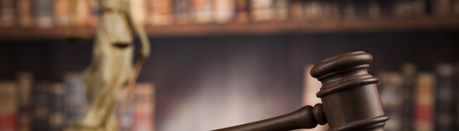 Law theme, mallet of the judge, wooden desk, books